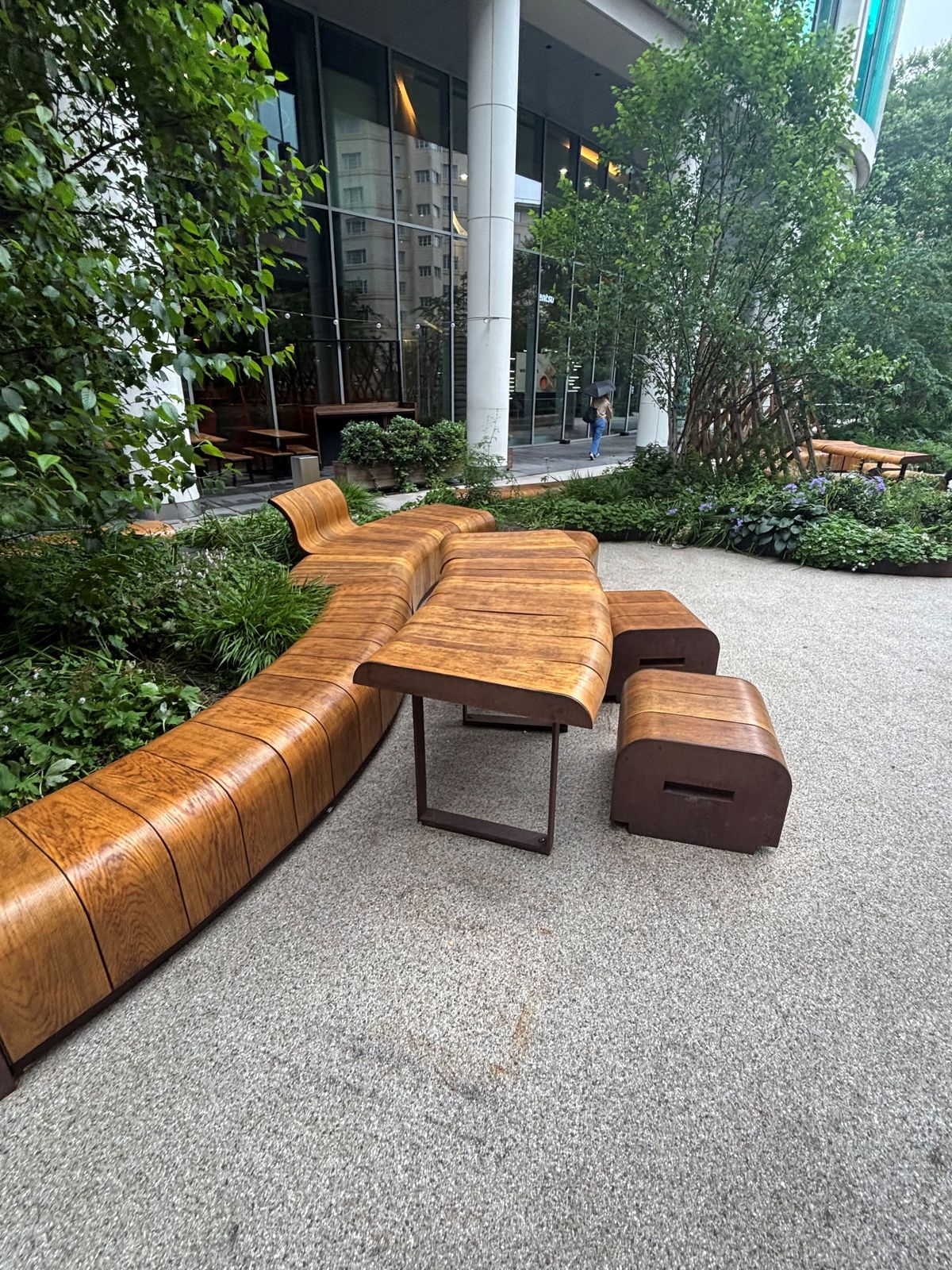 Bespoke curved timber bench seating in a landscaped courtyard by DPK Carpentry & Decorating