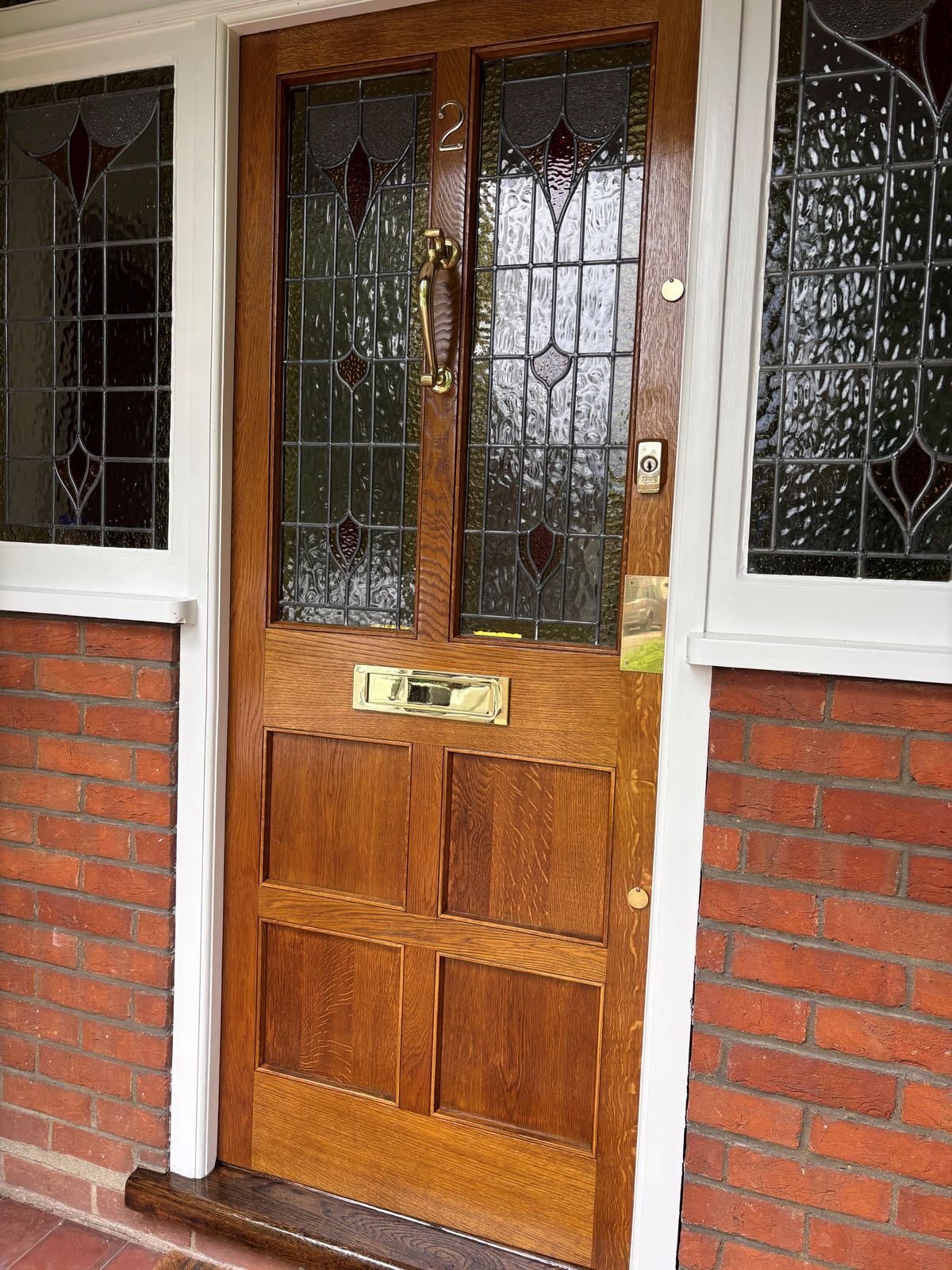 Restored oak front door with stained glass and brass hardware — bespoke joinery by DPK Carpentry & Decorating