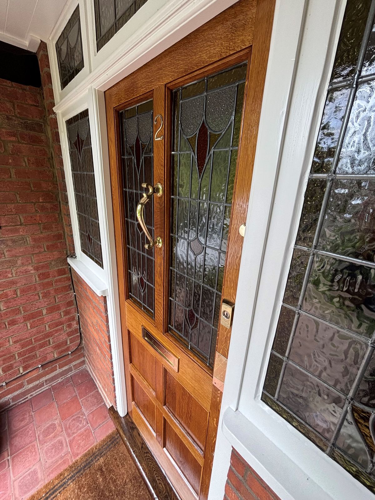 Oak front door and stained glass porch detail by DPK Carpentry